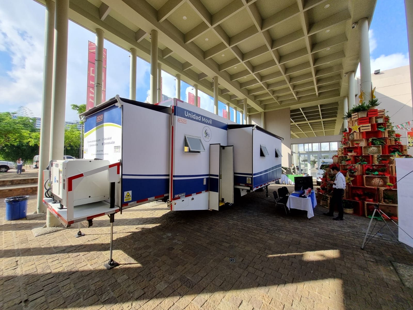 The unit deployed at a community health event, with its expanded module open and medical staff attending to the public.