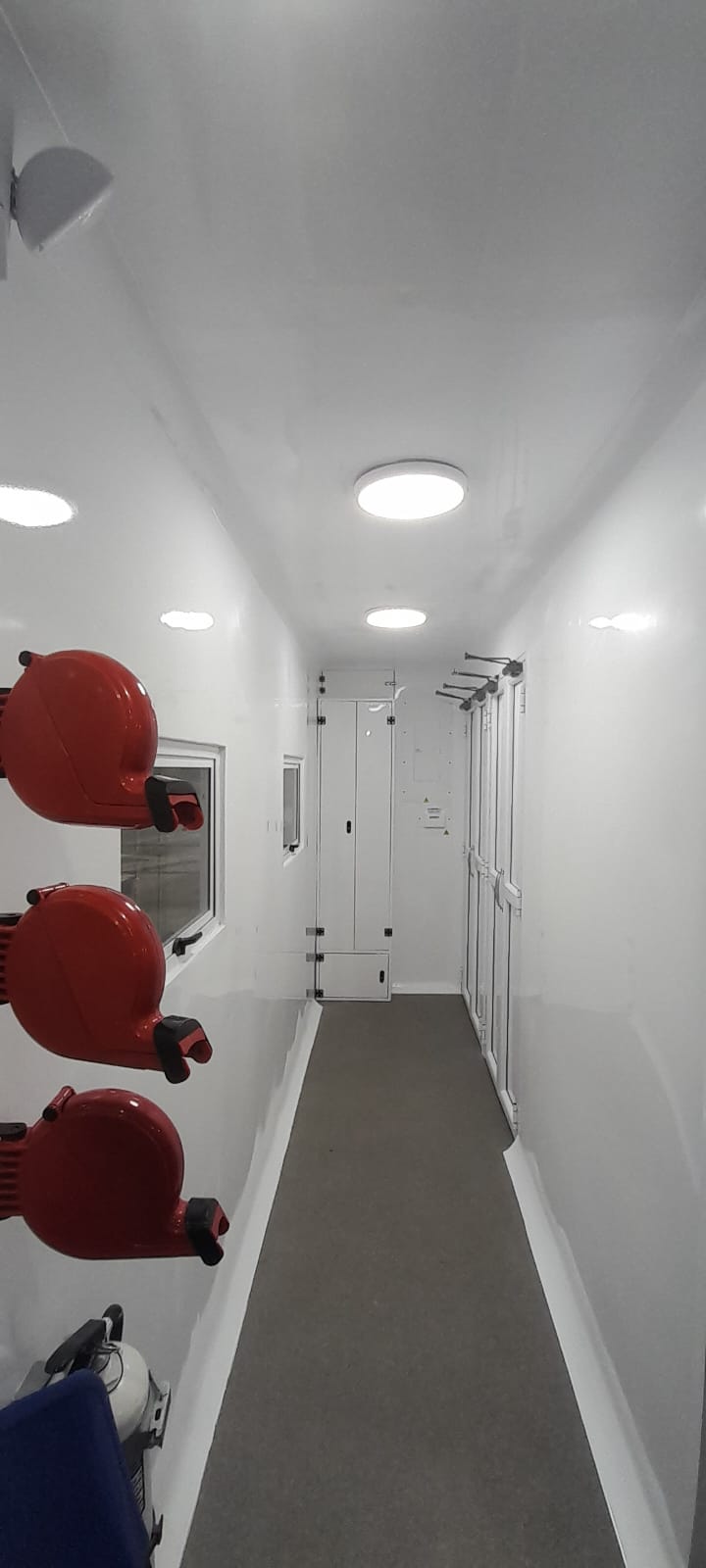 The unit's central corridor, showing the full depth of the interior with recessed LED lighting, compartment doors, and sanitary-grade finishes.